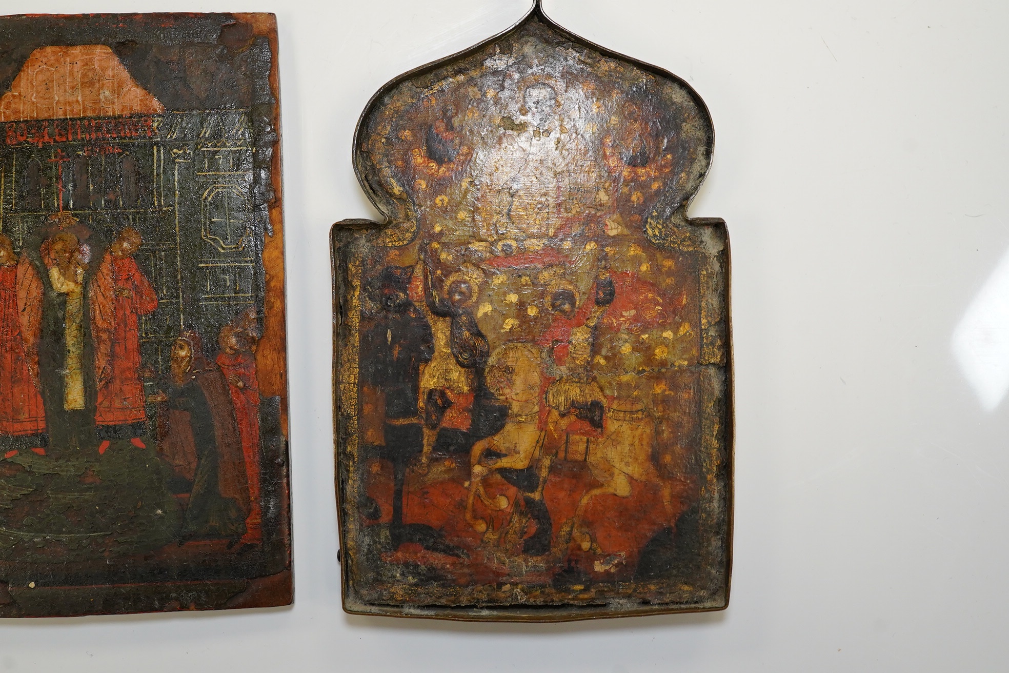 A pair of 17th century or later Russian painted wood icons, and another similar, 13.5 x 10cm. Condition - poor to fair